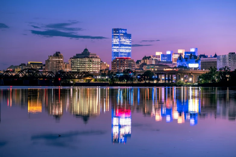 a city skyline reflected in a lake as the sun sets