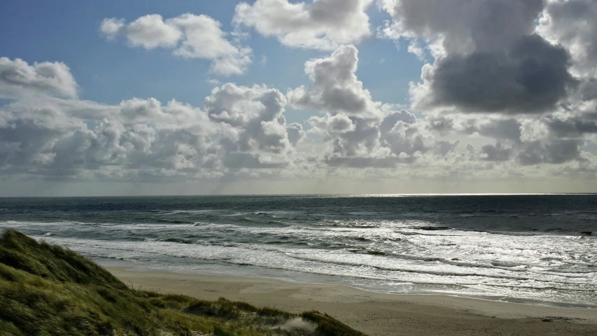 the view of a beach in front of an overcast sky