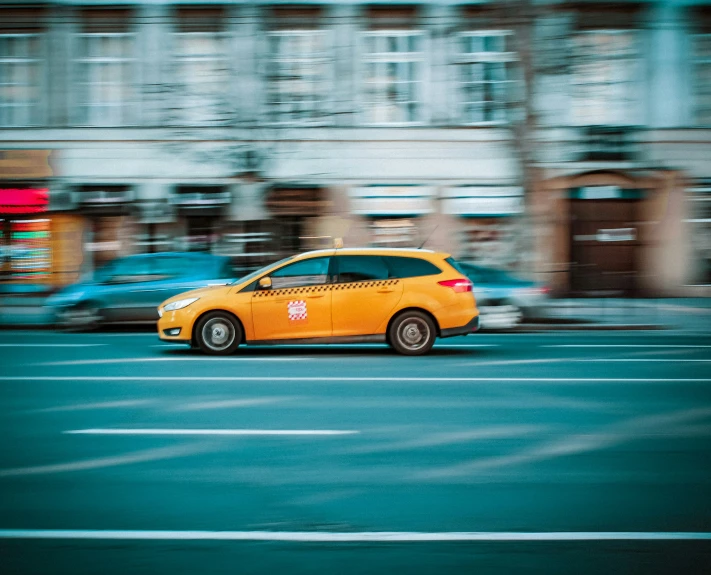 an orange taxi cab is on a street