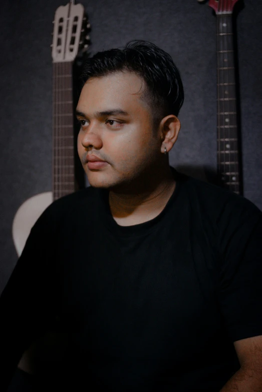 a man is sitting in front of a guitar