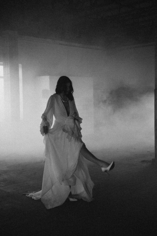 a woman in white is standing in the fog