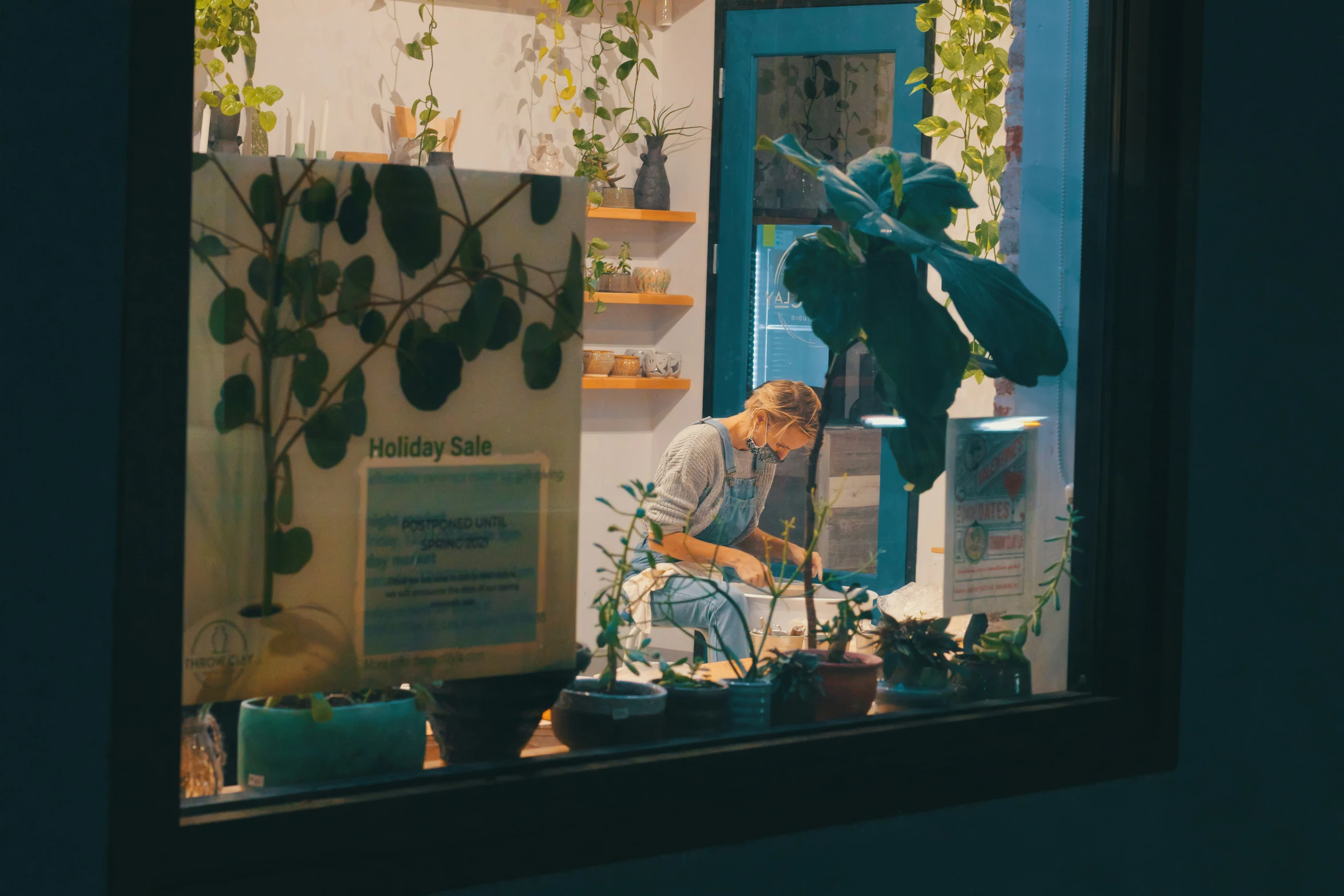 a woman who is kneeling down and using a plant pot