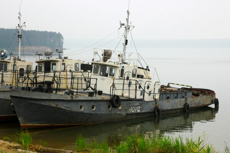 two boats with writing on the sides are docked together