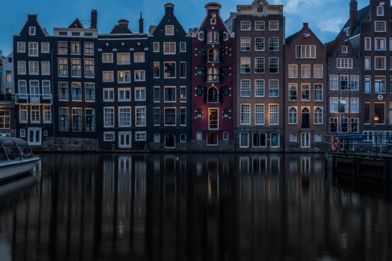 several buildings are next to the river during sunset