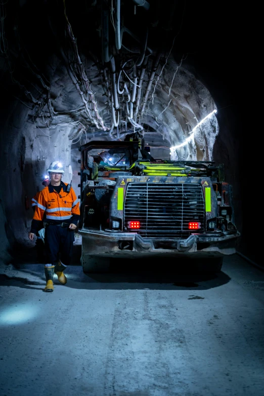 a man standing near a large truck in a tunnel