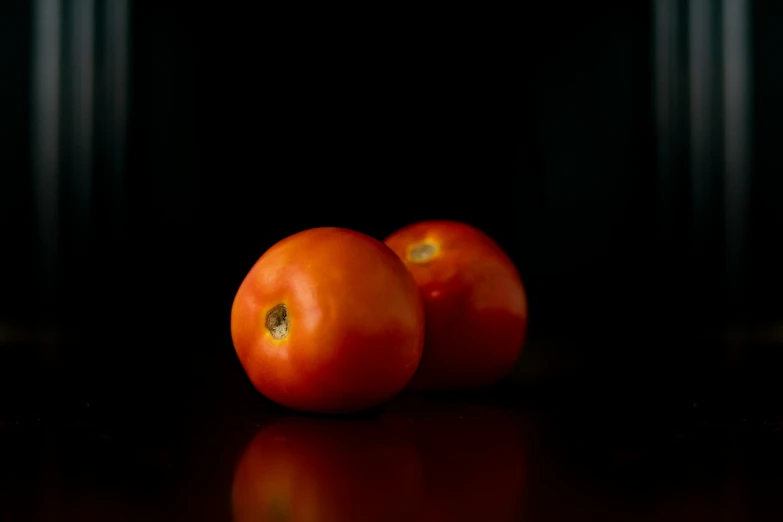 three oranges in a group on a black surface