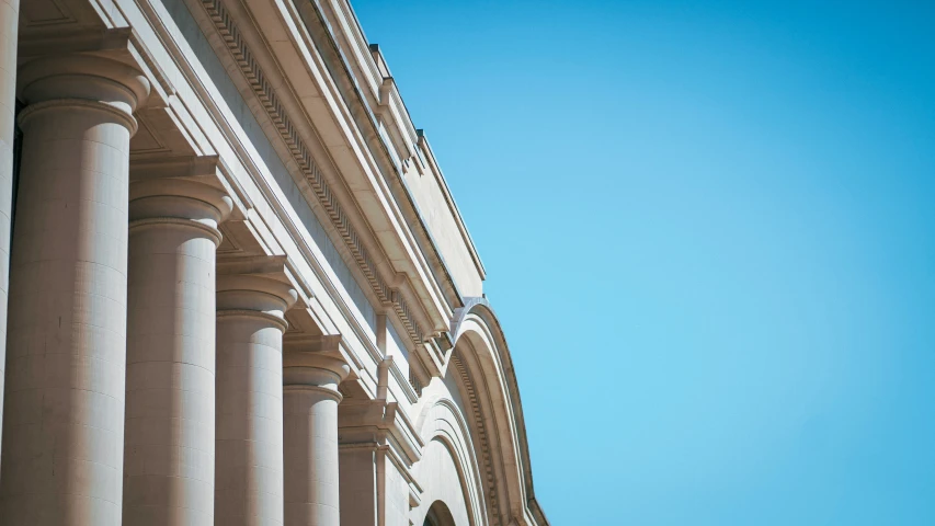 white columns of an ancient building against blue sky