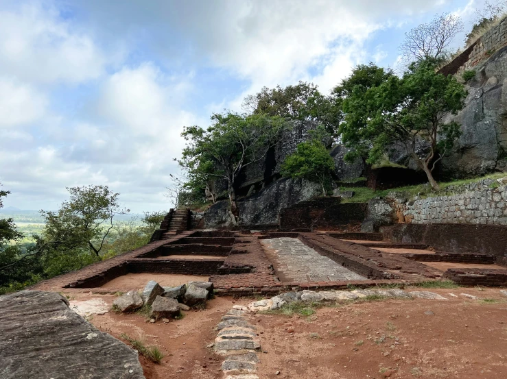 ancient ruins are on a rocky cliff with grass