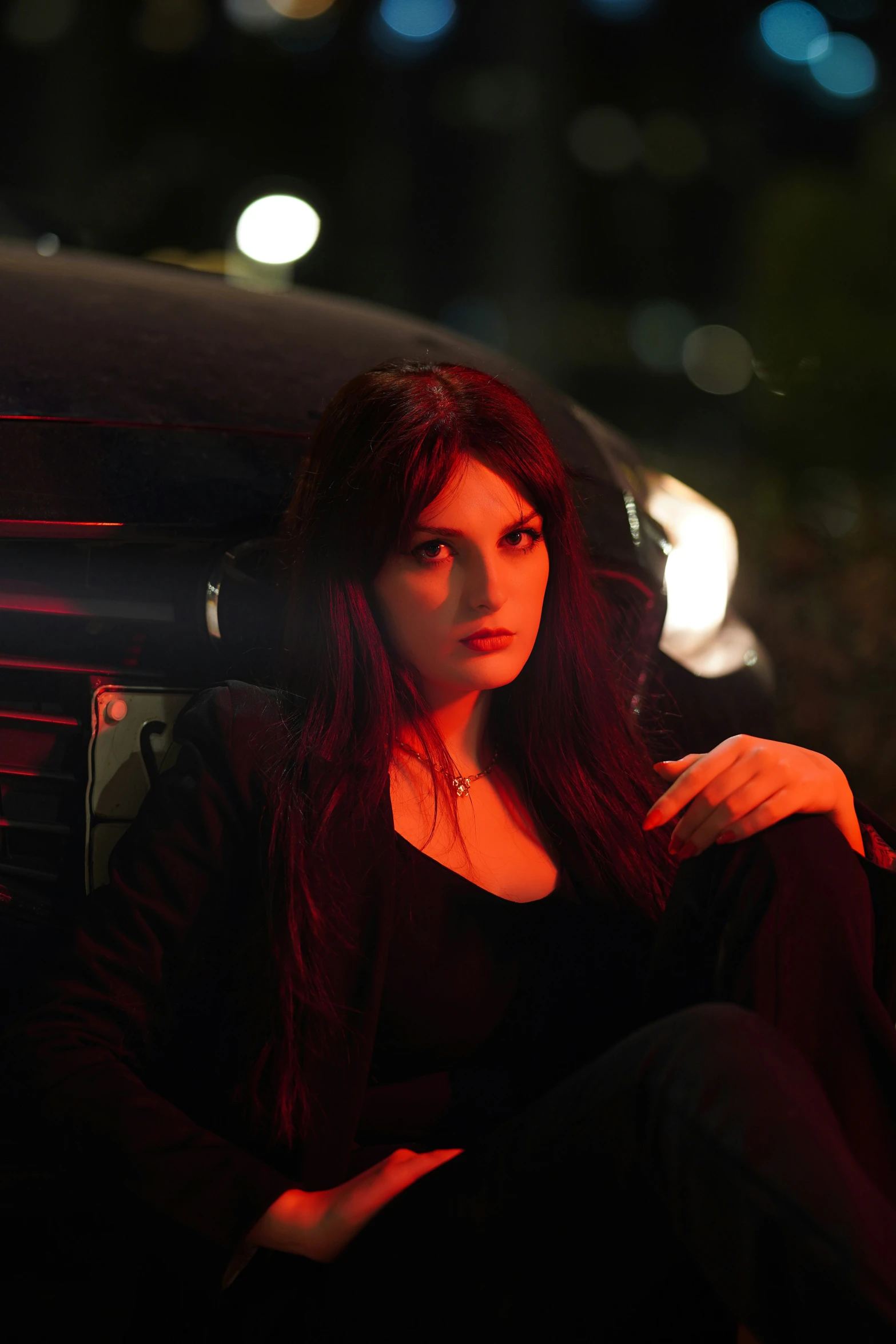 a woman sitting inside of a car next to a street