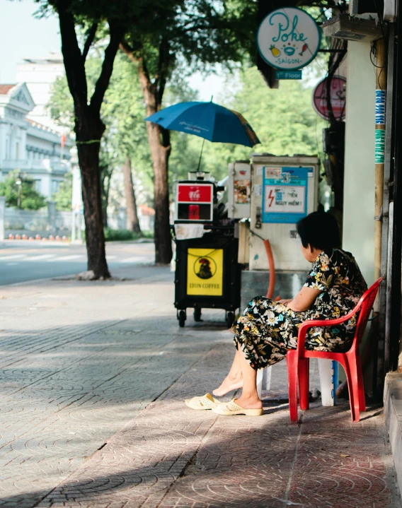 woman sitting on a bench with an umbrella