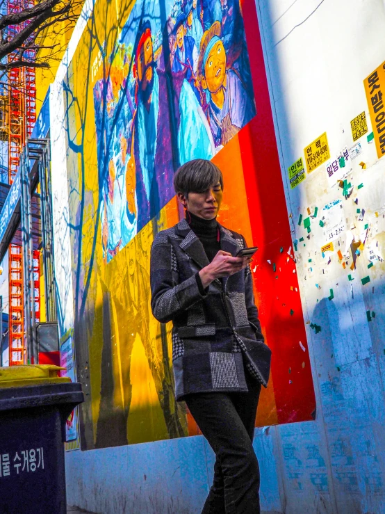 an asian man walking in front of a wall