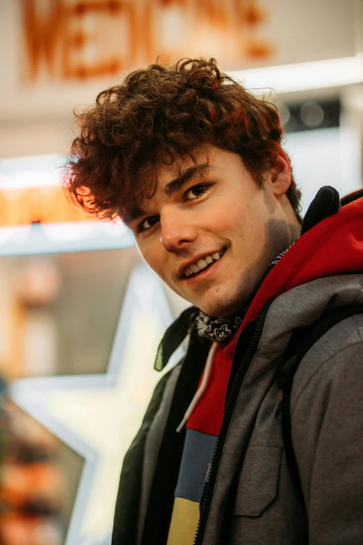 the man has curly hair and a red jacket