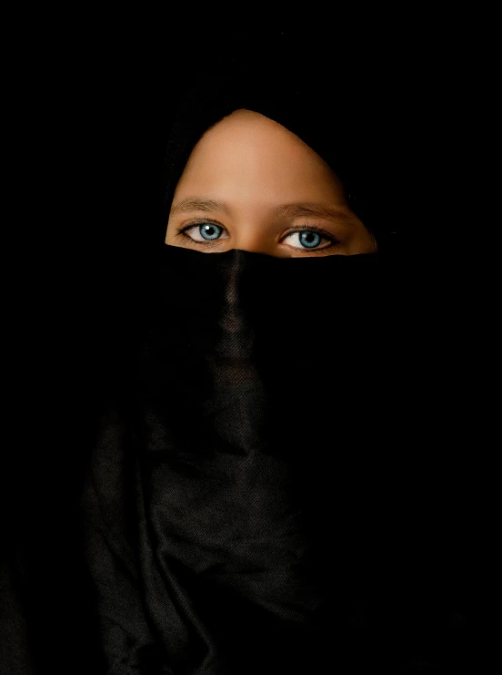 a woman's face is covered in black veil