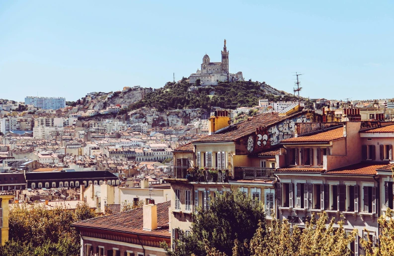 some very tall buildings with a big hill in the background