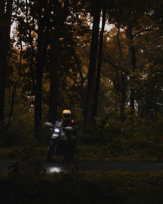 a person wearing a yellow helmet rides a black motorcycle