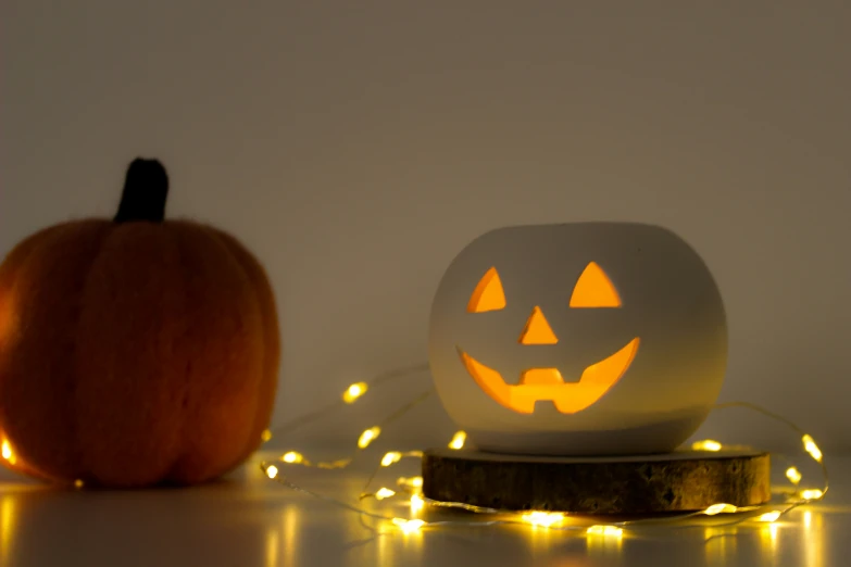 a pumpkin carved from a toilet roll and glowing with fairy lights