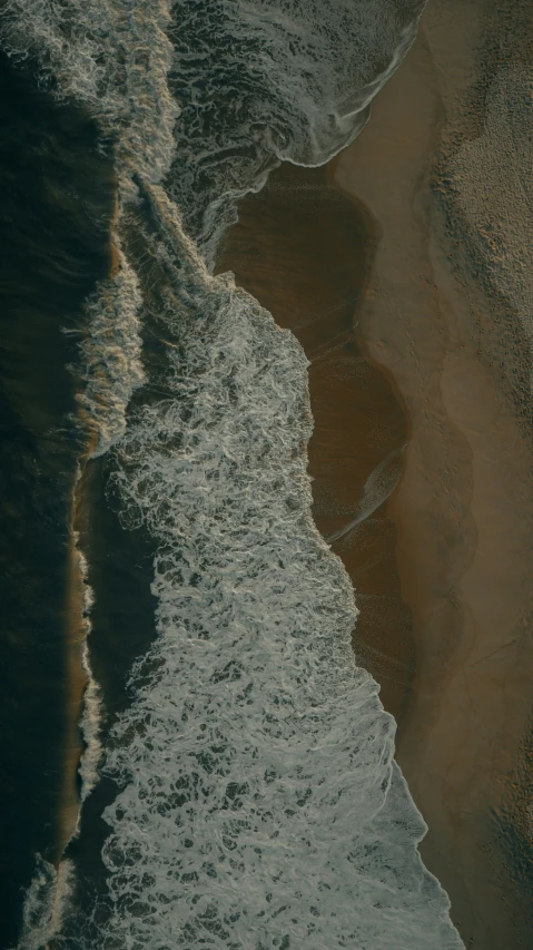 a view of some brown sand and water at the beach