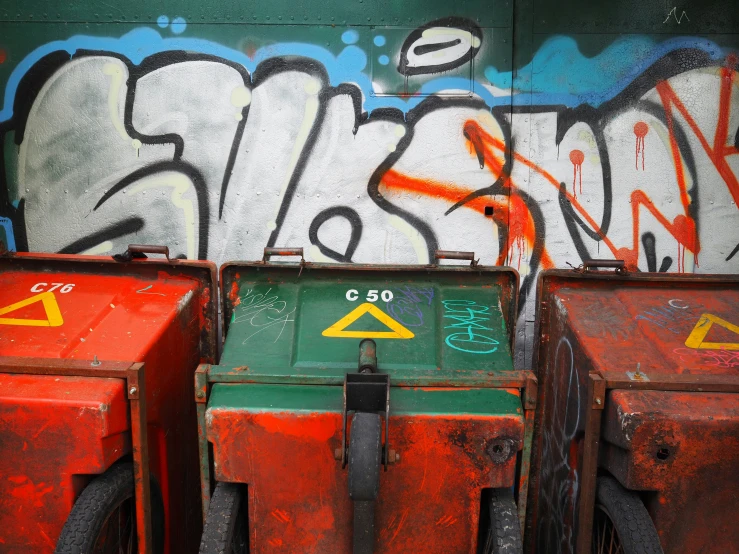 several boxes are sitting near graffiti on the wall