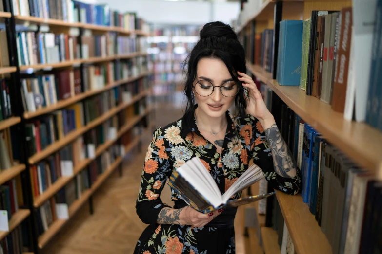 a girl is reading on a book in the liry