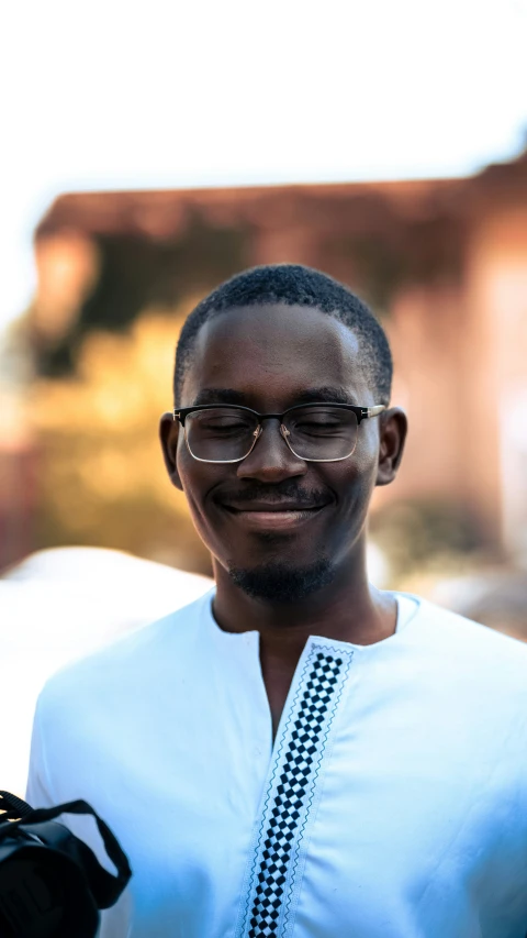 a man in glasses and a white shirt smiling