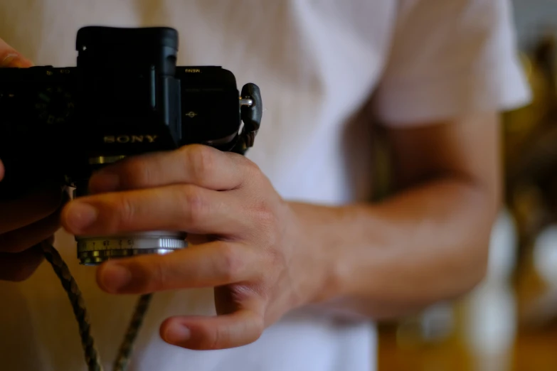 a camera held in the palm of someone holding a string