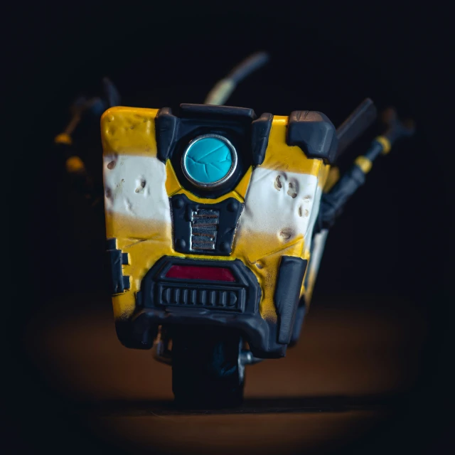 a yellow and black transformer toy with one eye on top