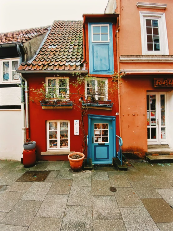 there is a blue door next to a red house