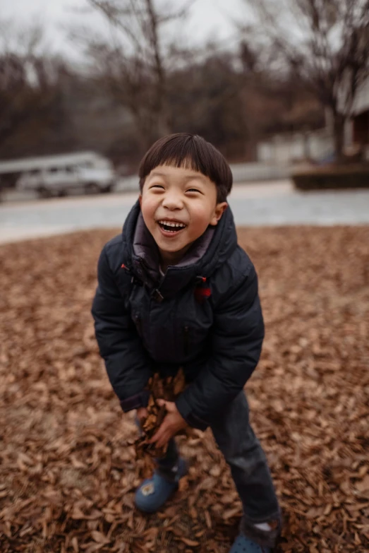 there is a  playing outside with leaves