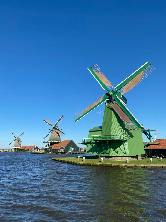 colorful wind mill on lake with grass and buildings