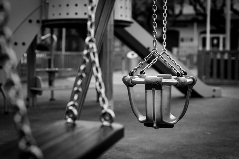 two children's swings with chains at a playground