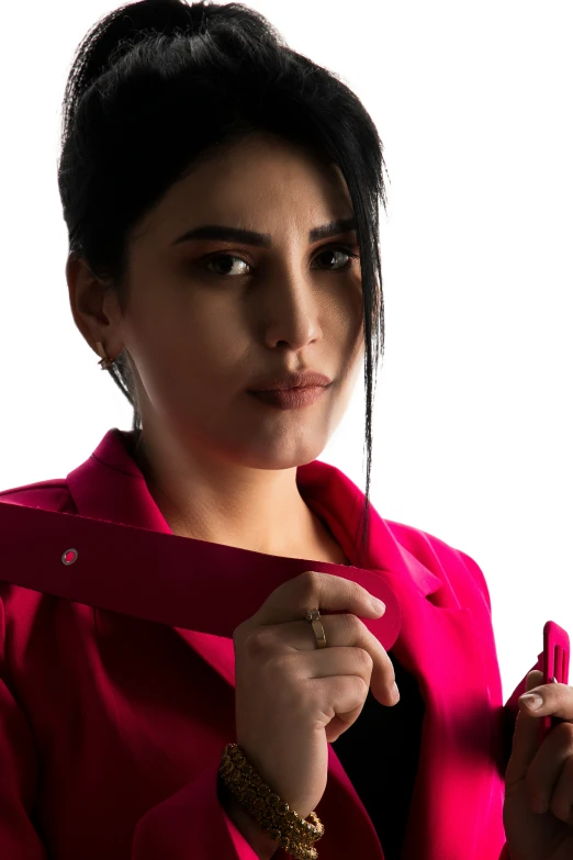 a woman in a red coat and ear rings tying a red tie