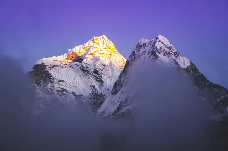 the view from below of a very tall snow covered mountain