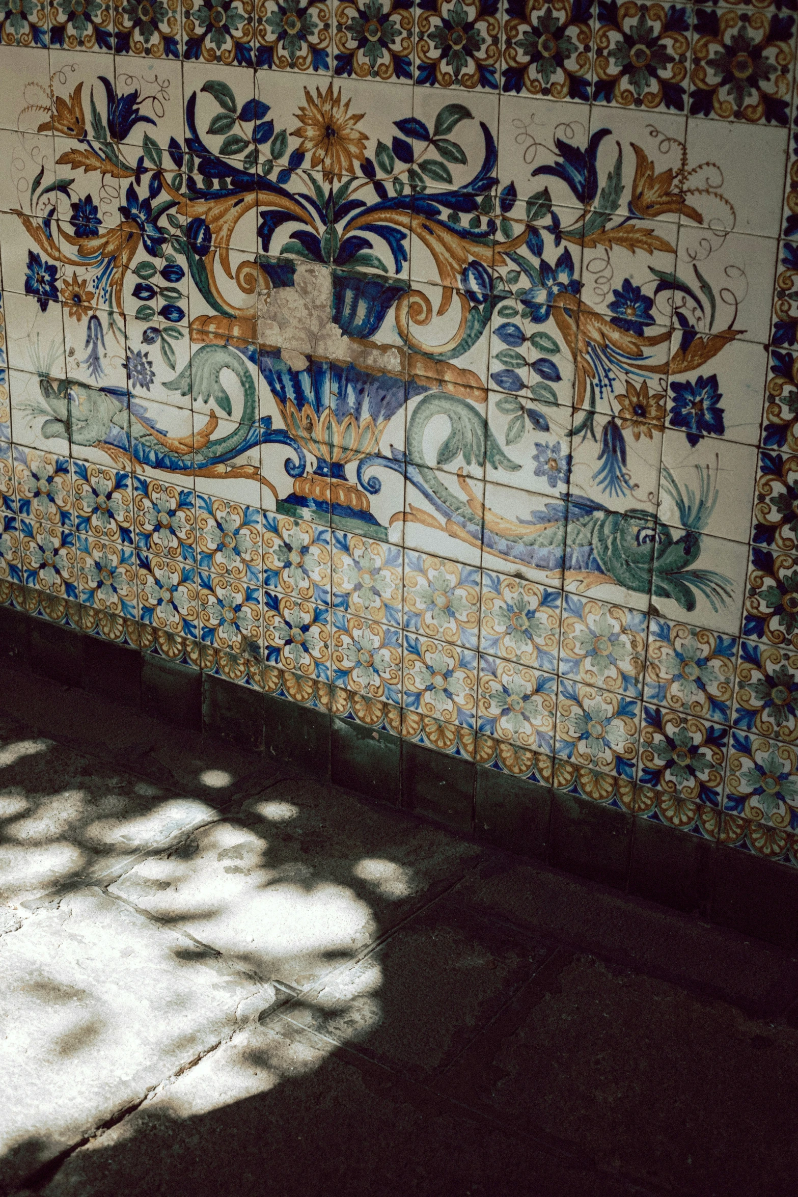 a wall with colorful floral design, and other tiles