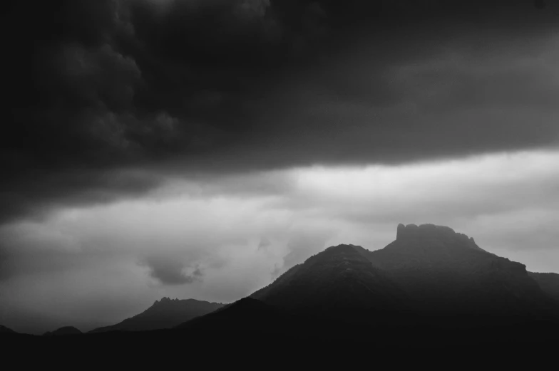 the top of a mountain in front of dark clouds