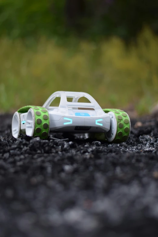 a car is sitting in the road with green and white wheels