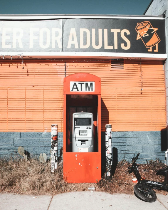 a street scene with a parked moped in front of an atm