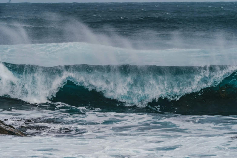 large wave near the edge of a rocky shoreline