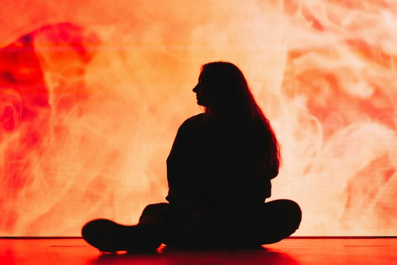 woman sitting on floor while looking at a big screen