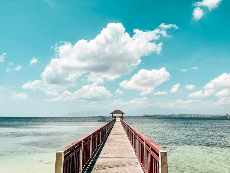 a long dock stretches into the ocean