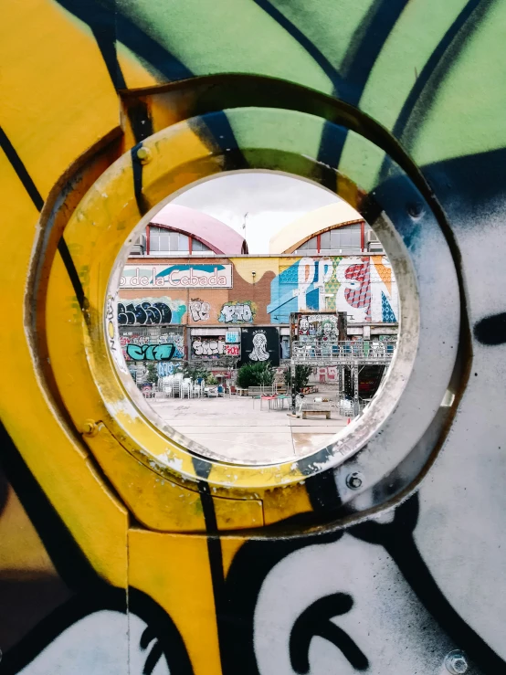 some graffiti and a round window on the wall