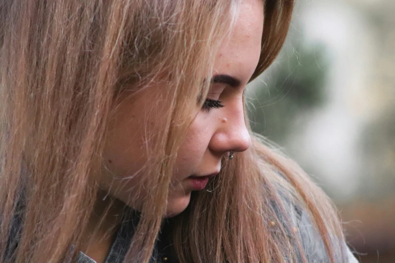 a girl with long hair wearing a ring earring