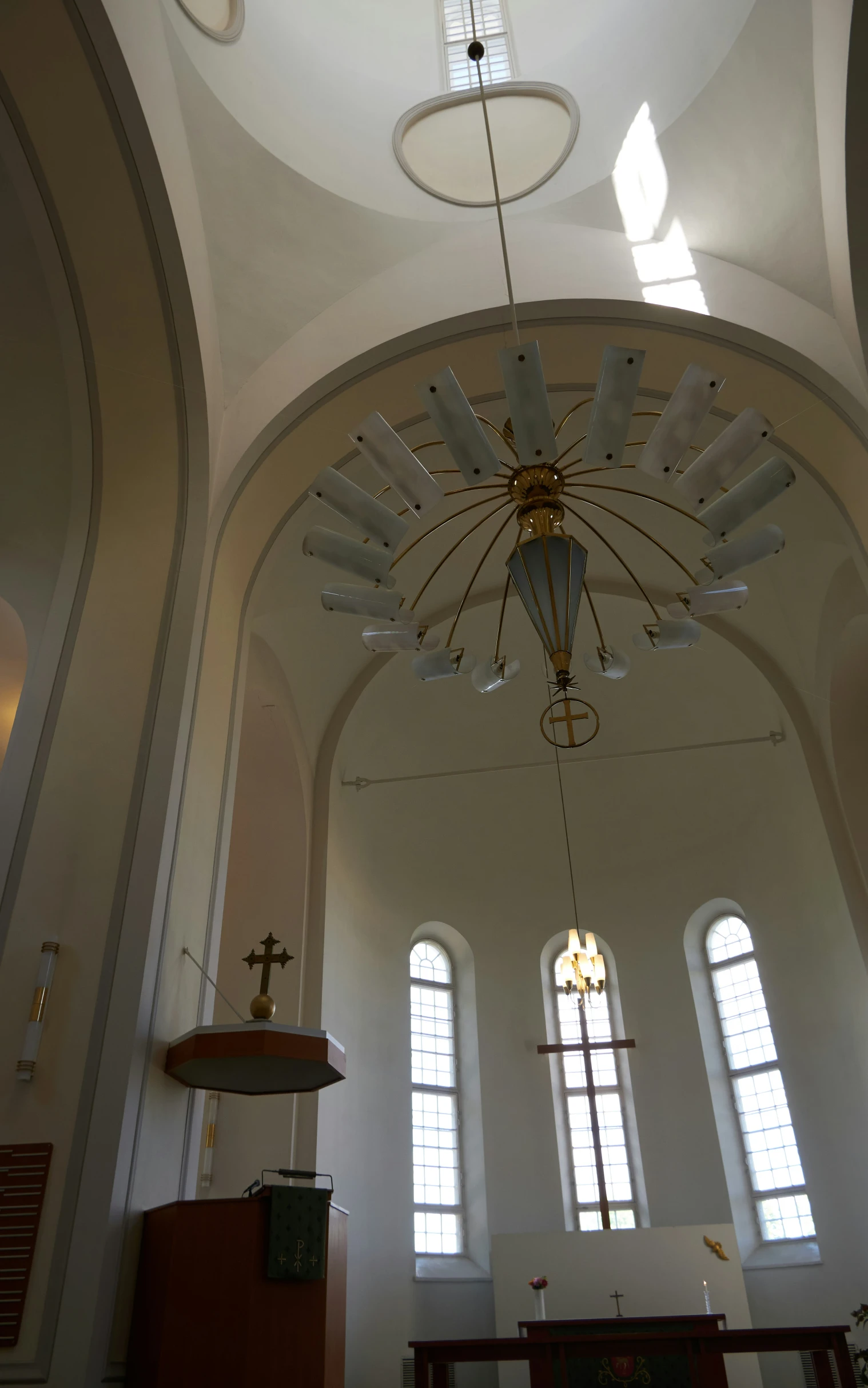 a church with chandelier, altar and stained glass windows