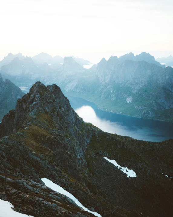 a mountaintop with some large rocks and water in the background