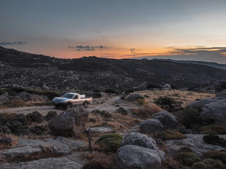 there is a car on the road at sunset