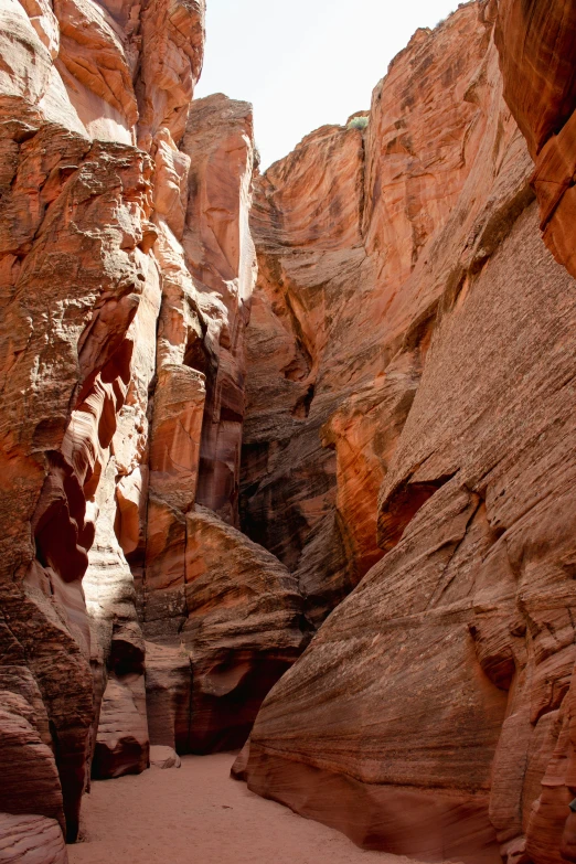 a person walking down a very narrow, rocky canyon