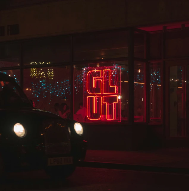 a car in front of a lit up window display