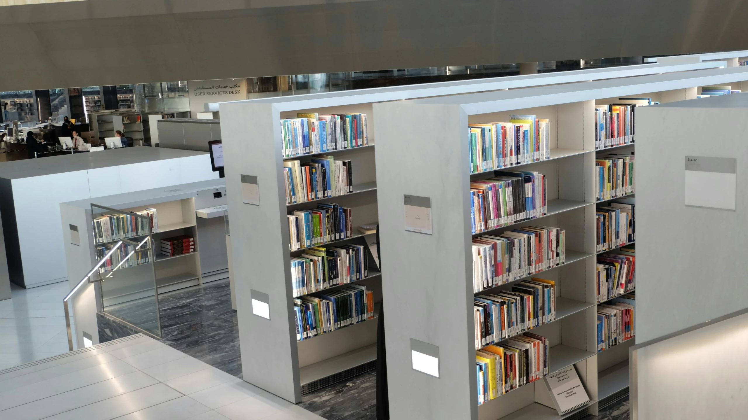 a bookcase filled with lots of books and sitting next to a staircase