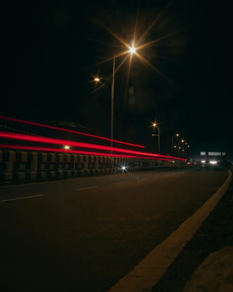an empty road with long exposure of street lights