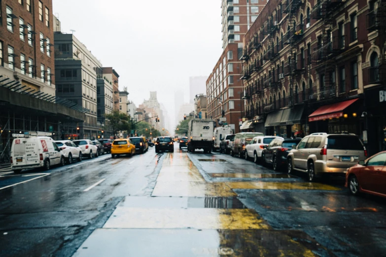 cars lined up on the side of a city street