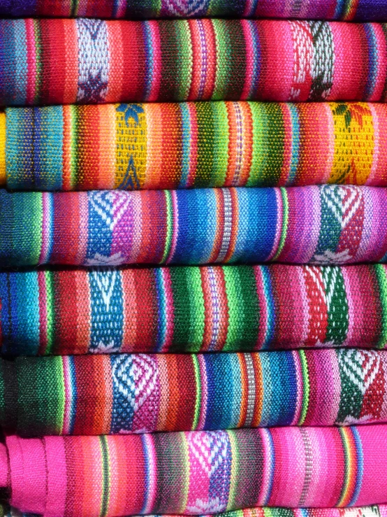 the folded towels have bright rainbow colored patterns